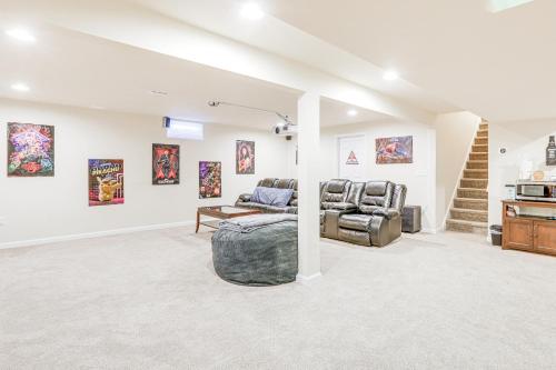 a living room with two chairs and paintings on the wall at Spacious Ewing Township Home Home Gym and Deck! 