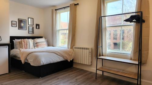 1 dormitorio con 1 cama y 2 ventanas en Bridge Street Apartments, en Peterborough