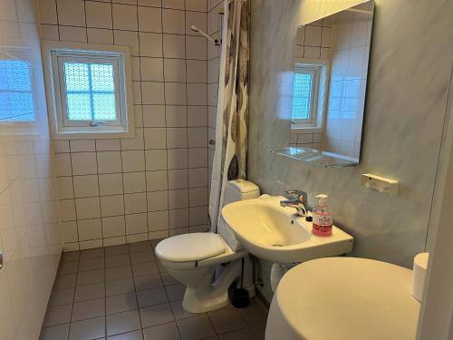 een witte badkamer met een toilet en een wastafel bij Langnes Camping, Grong in Grong