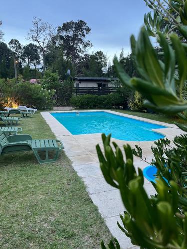 una piscina en un patio con tumbonas en Cabañas del Este, en Sauce de Portezuelo