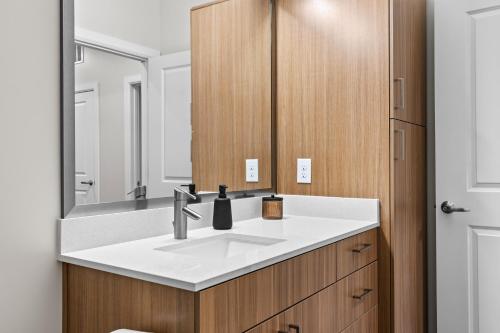 La salle de bains est pourvue d'un lavabo et d'un miroir. dans l'établissement Midnight Manor Penthouse Suite The Gulch, à Nashville