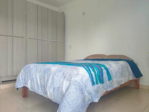 a bed with a white blanket on top of it at CASA CORAZA in Cancún