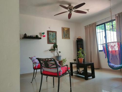 uma sala de estar com 2 cadeiras e uma ventoinha de tecto em CASA CORAZA em Cancún