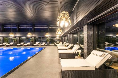 a hotel lobby with a pool and lounge chairs at Top - Seaside Appartement mit Meerblick in Timmendorfer Strand