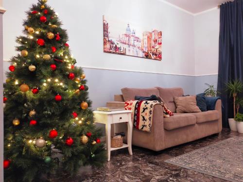 een kerstboom in een woonkamer met een bank bij San Felice in Favaro Veneto