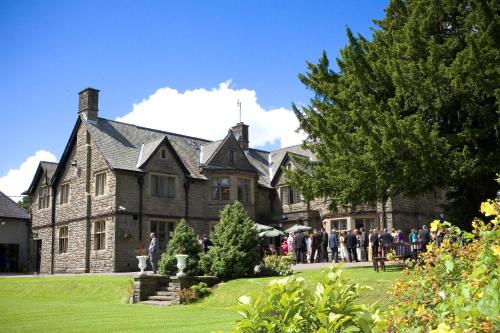 a group of people standing in front of a large house at Maes Manor Country Hotel in Blackwood
