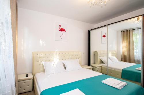 1 dormitorio con 2 camas y espejo en Apartament Brazda - Rendez Vous, en Craiova