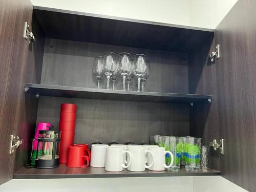 a shelf with cups and wine glasses on it at Villa Callarí in El Zapote