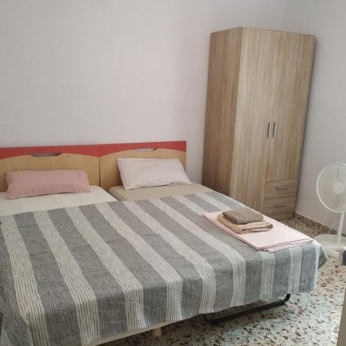 1 dormitorio con 1 cama y armario de madera en Habitacion privada y tranquila, en Alicante