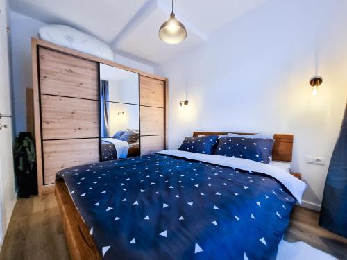 a bedroom with a large bed with blue sheets at Vucko Slopes Apartment Bjelasnica in Bjelašnica