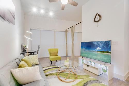 uma sala de estar com um sofá e uma televisão em Chic loft style 2BR I Gym I Parking I Workspace em Dallas