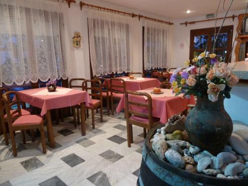 um restaurante com mesas e cadeiras e um vaso de flores em Paris Beach Hotel em Iraion