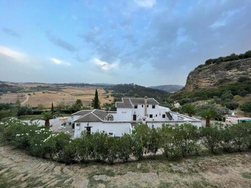 ein großes weißes Haus inmitten eines Berges in der Unterkunft Hotel La Hoya del Tajo in Ronda