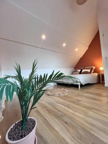 une plante en pot dans une pièce avec deux lits dans l'établissement Maison Aveny Spa, à Aveny