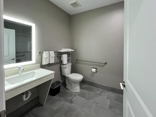 a bathroom with a toilet and a sink and a mirror at Studio 6 Katy, TX Energy Corridor in Katy