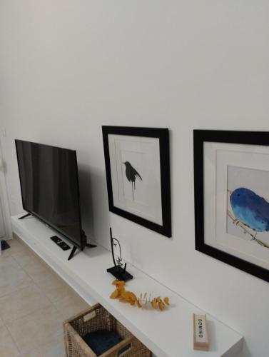 un salon avec une télévision et des photos sur le mur dans l'établissement Best Point, à Alexandroúpolis