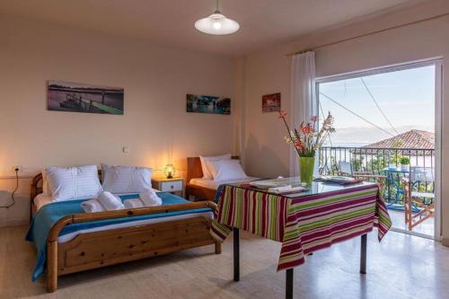 a bedroom with a bed and a table and a balcony at MAKAROUNIS THEA II in Petalidi