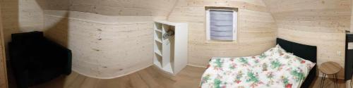 um pequeno quarto com uma cama e uma janela em Nadmorska Sarbinowo em Sarbinowo