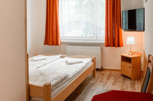 ザコパネにあるPokoje Banaśのベッドルーム1室(ベッド1台付)、窓(オレンジ色のカーテン付)