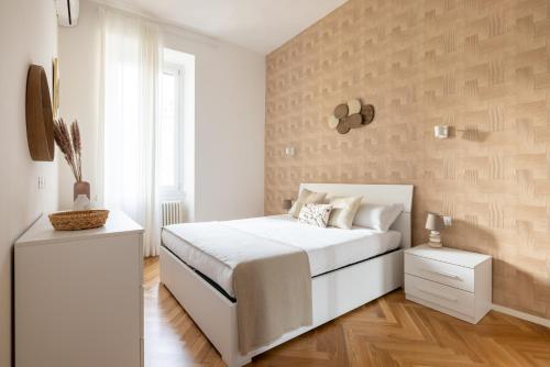 una camera con un letto bianco e un muro di Charming Vatican Apartment a Roma