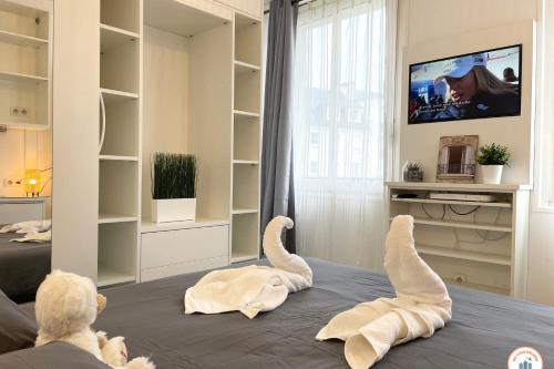 2 animaux farcis pondant sur un lit en regardant la télévision dans l'établissement Le Palais des Glaces - Hypercentre - Port, à Caen