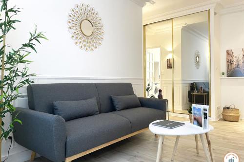 un salon avec un canapé et une table dans l'établissement Le Palais des Glaces - Hypercentre - Port, à Caen