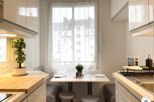 - une cuisine avec une table et 2 verres à vin dans l'établissement Le Palais des Glaces - Hypercentre - Port, à Caen