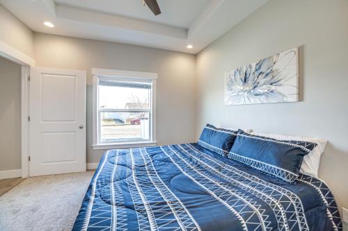Un dormitorio con una cama azul y una ventana en Charming Idaho Falls Home - 5 Mi to Downtown! en Idaho Falls