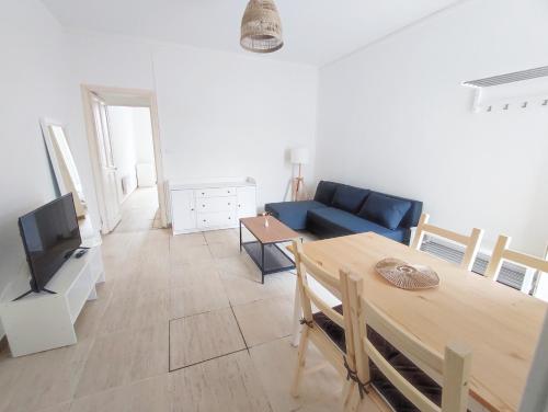 un salon avec un canapé bleu et une table dans l'établissement Bel appartement centre de Nîmes, à Nîmes