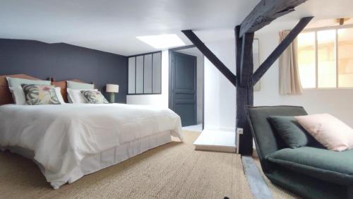 1 dormitorio con 1 cama y 1 sofá en Maison Charmeilles - Gîte touristique - Coliving en Fronsac