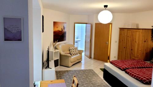 a living room with a couch and a chair in a room at Wohlfühl-Ferienwohnung mit Tiefgarage im Grünen in Oberhof