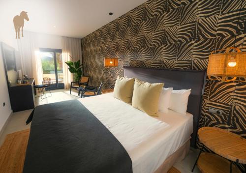 Un dormitorio con una cama grande y una pared con un patrón. en Alcaidesa Boutique Hotel en Alcaidesa