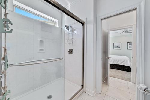 La salle de bains est pourvue d'une douche avec une porte en verre. dans l'établissement Driftwood Dream, à Orange Beach