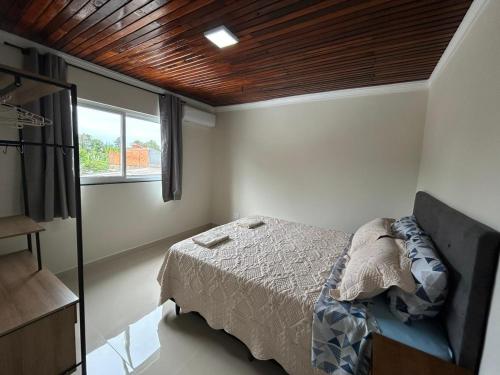 a bedroom with a bed and a window at Aconchego, no melhor lugar de Foz! in Foz do Iguaçu