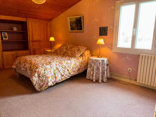 ein Schlafzimmer mit einem Bett, zwei Lampen und einem Fenster in der Unterkunft Les clés de Jonzacconciergerie, Villa les oiseaux in Jonzac