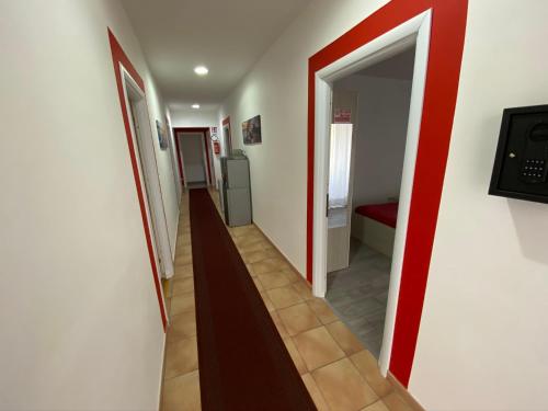 a hallway with a red stripe on the wall at Coral Rooms in Torre del Greco