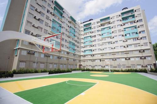 an apartment building with a basketball court in front of it at Ezzel’s Place at Marina Spatial Dumaguete City in Dumaguete