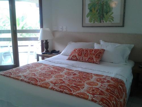 a bedroom with a bed with a red and white blanket at Jatiúca Resort Flat 404 in Maceió