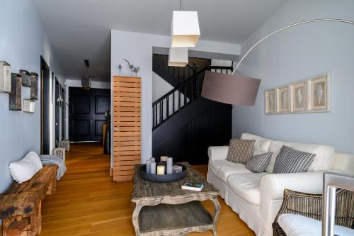 a living room with a white couch and a staircase at Seaside Resort Home in Pylos