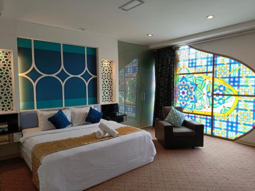 a bedroom with a bed and a stained glass window at Hotel Zara in Sungai Petani