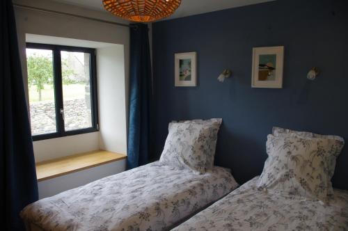 a bedroom with two beds next to a window at Superbe Maison en baie du Mont St Michel in Vains