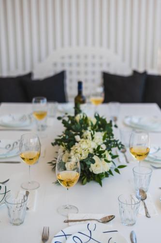 a white table with wine glasses and a flower centerpiece at Seaside Resort Home in Pylos