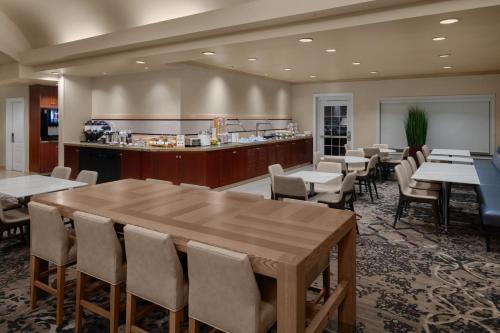 a restaurant with a large wooden table and chairs at Residence Inn East Rutherford Meadowlands in East Rutherford