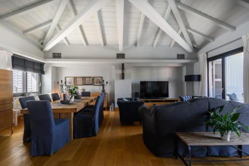 a dining room with a long table and blue chairs at Seaside Resort Home in Pylos