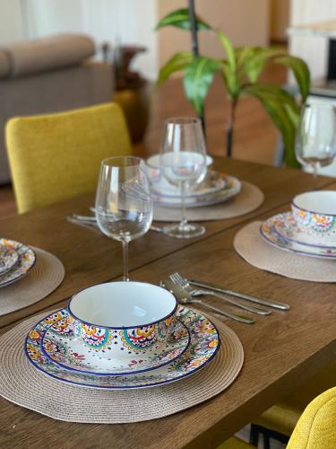 a wooden table with plates and wine glasses on it at Family Perfect with Fireplace Vacation Home in Little Elm