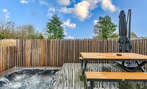 a patio with a table and an umbrella and a fence at Villa Le Brame in Ciney