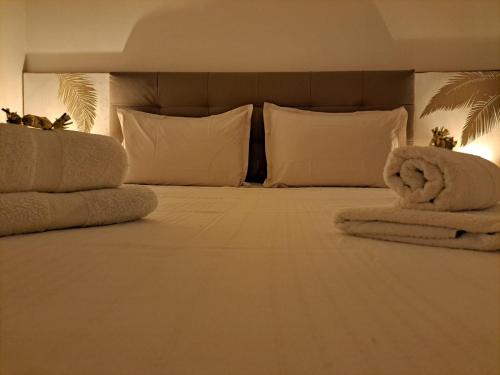 a bedroom with a bed with white pillows and towels at Ste Luce, N° 11 Appart -300m Plage de Mabouyas in Corps de Garde