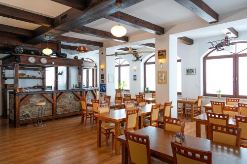 a restaurant with wooden tables and chairs and a fireplace at Kikity Siedlisko z lądowiskiem in Kolno