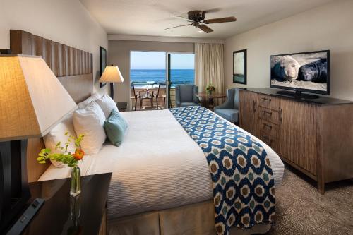 a hotel room with a bed and a view of the ocean at Cambria Landing Inn and Suites in Cambria