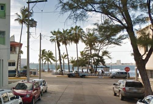 a parking lot with cars parked next to the beach at Departamento en el Área de Olas Altas in Mazatlán